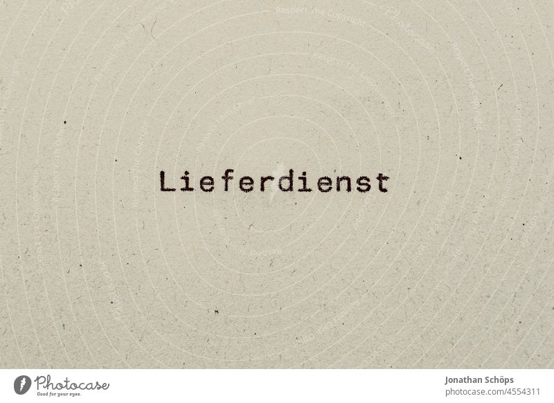 Lieferdienst als Text auf Papier mit Schreibmaschine Paketlieferung Recycling Schrift Typografie analog liefern retro text textfreiraum vintage Buchstaben Wort