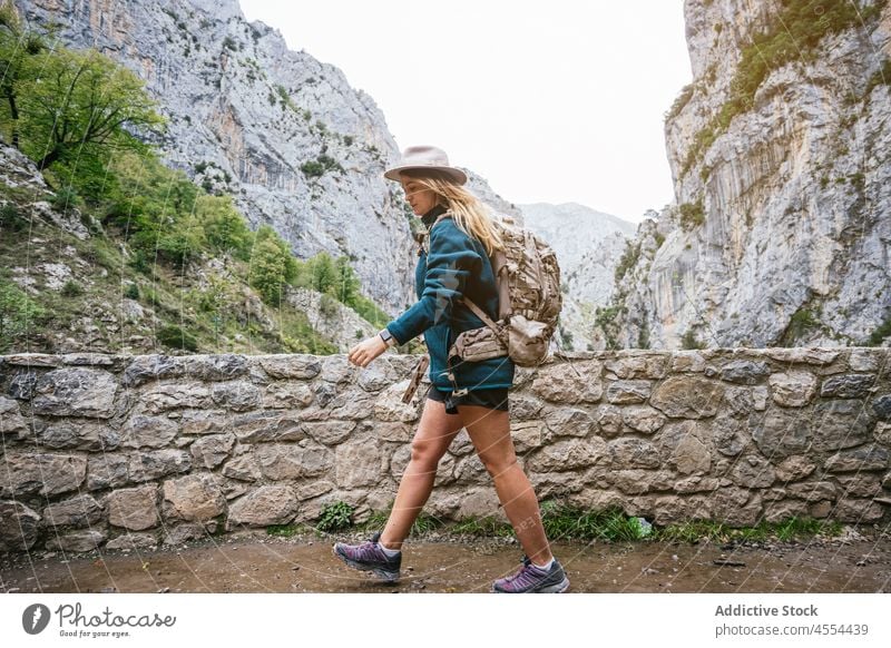 Junge Frau geht auf einem Pfad in bergigem Gelände spazieren Backpacker erkunden Trekking Berge u. Gebirge Hochland Berghang Ambitus steil Fundstück Umwelt Weg