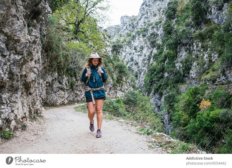 Junge Frau geht auf einem Pfad in bergigem Gelände spazieren Backpacker erkunden Trekking Berge u. Gebirge Hochland Berghang Ambitus steil Fundstück Umwelt Weg