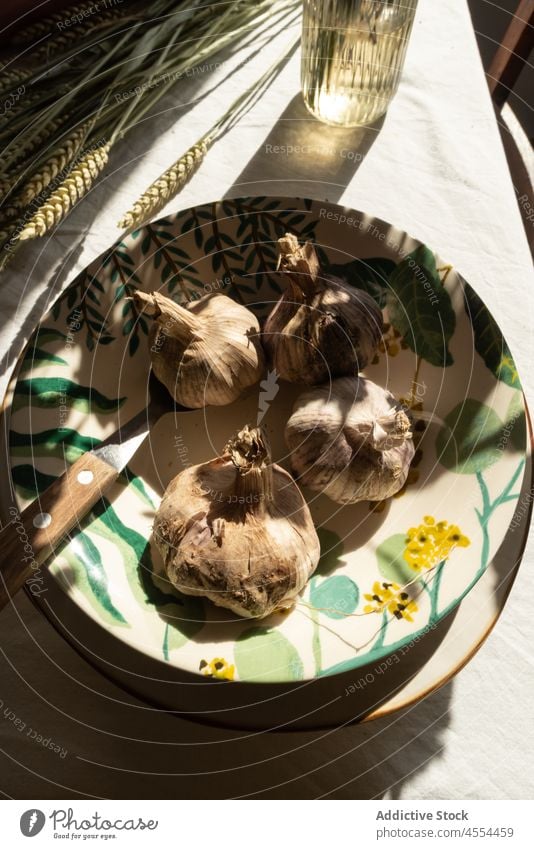 Schale mit Knoblauch neben Grasbüschel Schalen & Schüsseln Ernte Spitze Roggen rustikal Landschaft Gemüse Müsli Lebensmittel Stillleben Keramik ganz Haufen