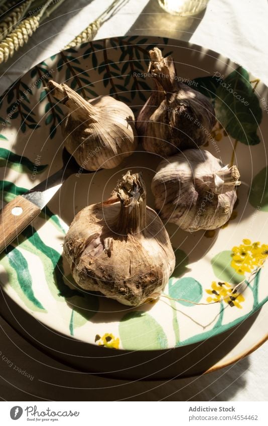 Schale mit Knoblauch neben Grasbüschel Schalen & Schüsseln Ernte Spitze Roggen rustikal Landschaft Gemüse Müsli Lebensmittel Stillleben Keramik ganz Haufen