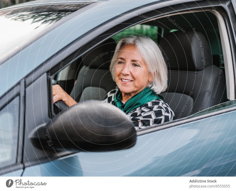 Ältere Frau in eleganter Kleidung fährt Auto PKW heiter Laufwerk Fahrzeug Lächeln Automobil Senior stilvoll Glück gealtert Rentnerin Sonne Fahrer positiv Outfit