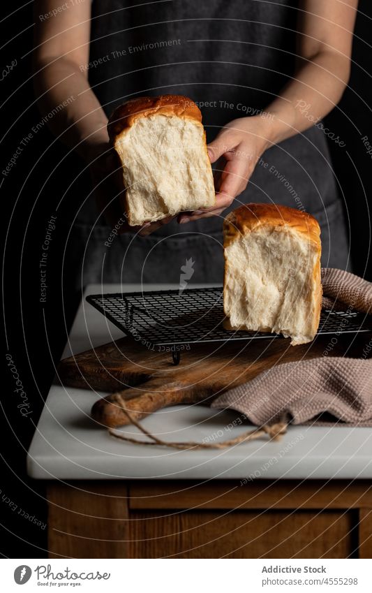 Crop Cook mit Sandwichbrot in dunkler Küche Koch Bäcker Brot Hälfte Split Belegtes Brot geschmackvoll gebacken lecker Lebensmittel Brotlaib appetitlich