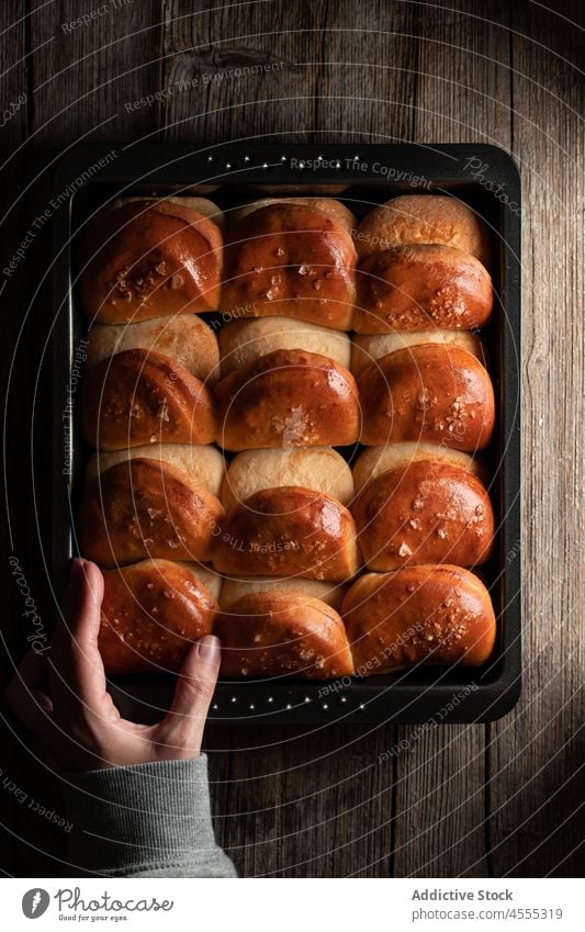 Crop-Bäcker mit frischen Brötchen im Fach Koch rollen leichtes Abendessen gebacken geschmackvoll lecker Lebensmittel Brot Backblech Küchenchef Tablett Reihe