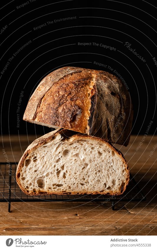 Gebackenes Sauerteigbrot in einer Grillpfanne auf einer Holzunterlage Brot Brotlaib Lebensmittel gebacken geschmackvoll Hälfte geschnitten Gebäck knirschen