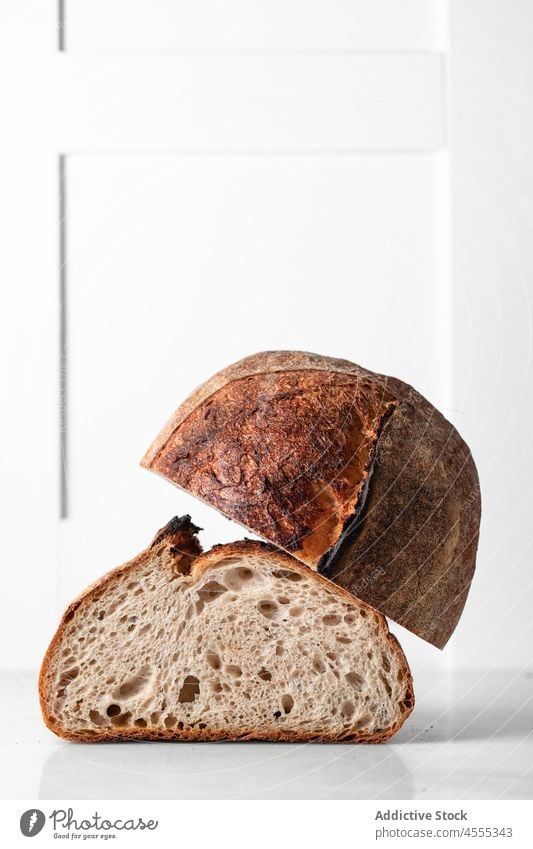 Gebackenes Sauerteigbrot auf dem Tisch Brot Brotlaib Lebensmittel gebacken geschmackvoll Hälfte geschnitten Gebäck knirschen Bäckerei Kruste Poore natürlich