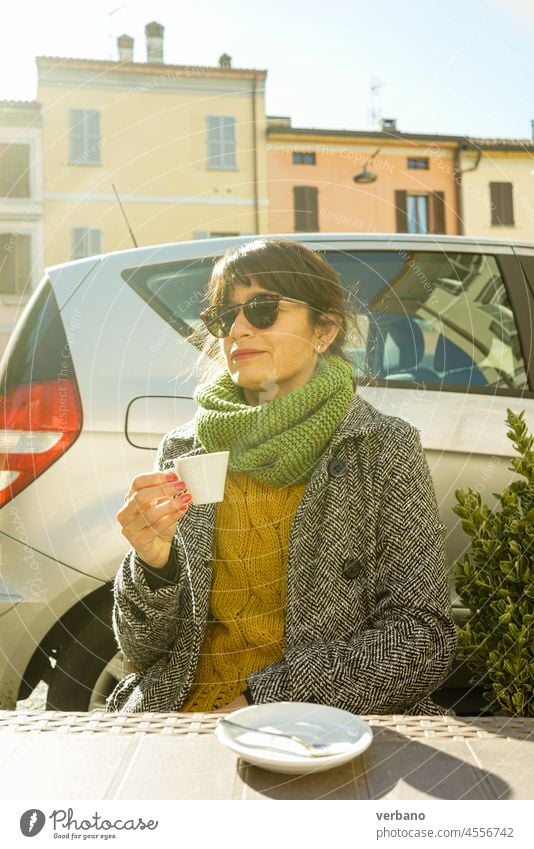 schöne erwachsene Frau mit einem Espresso Kaffee im Freien im Winter einen sonnigen Tag Morgen trinken lateinamerikanisch brünett Tasse Café Frühstück Lifestyle