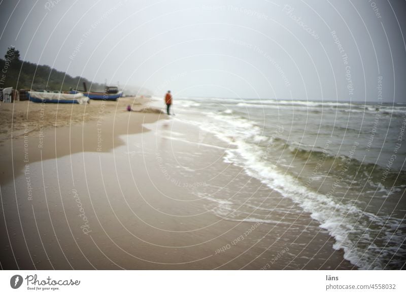 trübes Wetter und alleine am Strand Ostsee einsam schlechtes Wetter Mensch Boote bedeckter Himmel Depression Leidensweg Küste Außenaufnahme Meer Horizont Sand