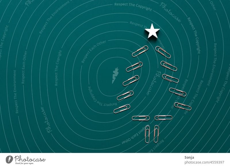 Ein Weihnachtsbaum aus Büroklammern auf einem blauen Hintergrund. Flat lay. Weihnachten & Advent Tanne Dekoration & Verzierung Idee Kreativität Winter Stern