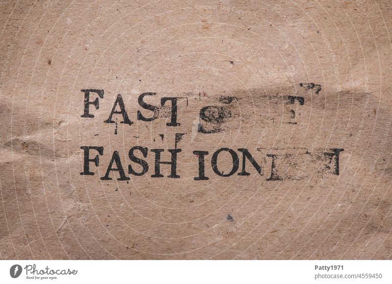 Gestempelter Text auf zerknittertem Papier. Fast Fashion. mode fast fashion verwischt wort umwelt umweltschädlich influencer papier grunge typen gestempelt