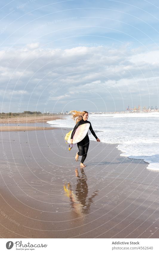 Frau mit Surfbrett läuft auf nassem Strand Küste rennen Ufer Hobby Freiheit Aktivität Zeitvertreib Sport MEER Wasser Gezeiten winken Hafengebiet Seeküste Natur