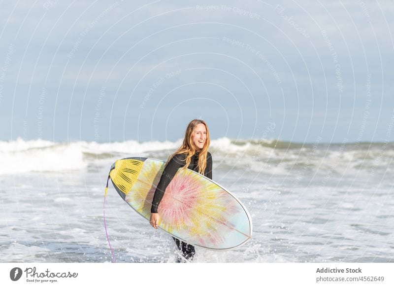 Frau Porträt mit Surfbrett im Meer in die Kamera schauen Hobby Aktivität Zeitvertreib Sport MEER Wasser Ufer Strand Gezeiten winken Hafengebiet Seeküste Natur