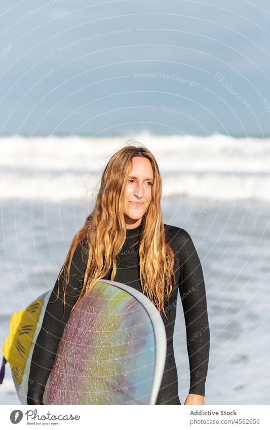 Frau mit Surfbrett im Meer Porträt MEER Hobby Aktivität Zeitvertreib sonnig Sport Wasser Ufer Strand Wegsehen Gezeiten winken Hafengebiet Seeküste Natur Gerät