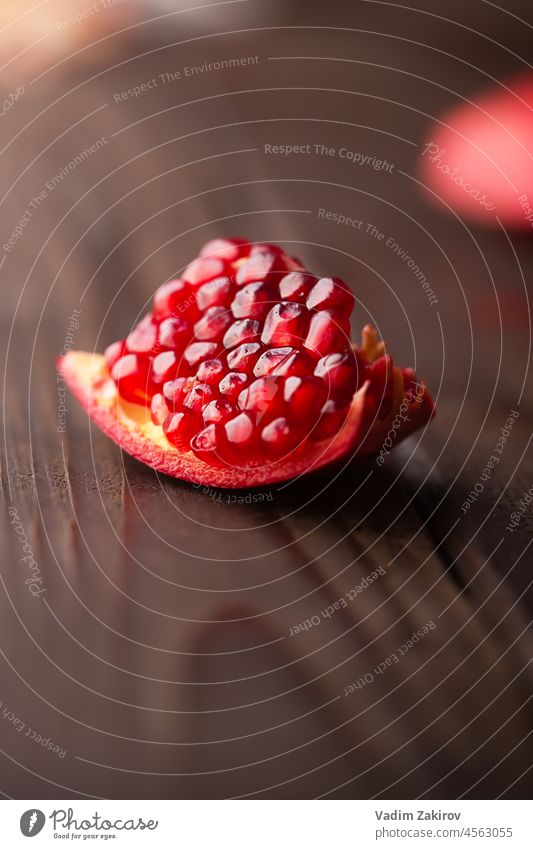 Granatapfelstück auf einem dunklen Holztisch Saft Selektiver Fokus frisch trinken Gesundheit hölzern Mineralien Vitamine Glas organisch Antioxidans Frucht