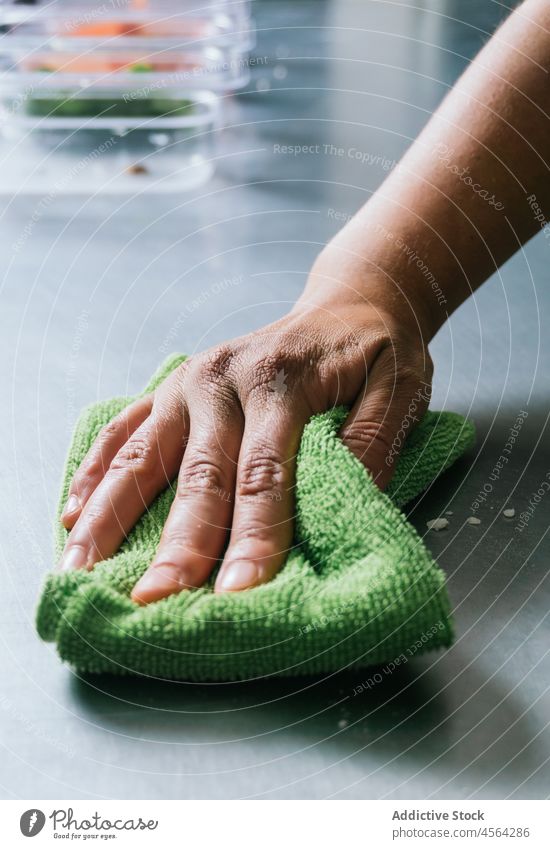 Frau am Herd wischt Tisch mit weichem Tuch ab Restaurant Küche Wischen Küchenchef professionell Koch Stoff vorbereiten Arbeit Stahl Uniform Sauberkeit Serviette