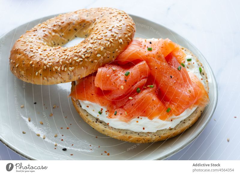 Bagel mit Lachs in leichter Küche Käse Lebensmittel Narr Frühstück Bäckerei geschmackvoll lecker dienen Teller Tisch Licht kulinarisch appetitlich Gastronomie