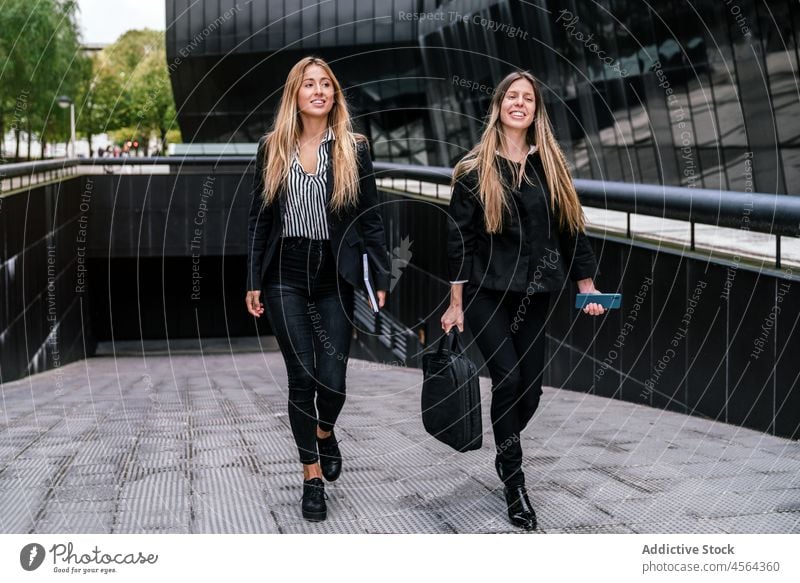 Fröhliche Geschäftsfrauen auf der Straße Gebäude Weg Laufsteg Zeit verbringen Großstadt urban modern Mitarbeiterin Kollege positiv Frau heiter Zusammensein