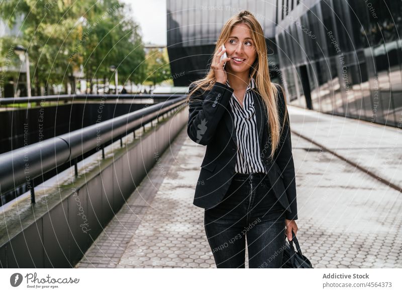 Geschäftsfrau spricht mit Smartphone auf der Straße Telefonanruf Gespräch diskutieren Gebäude Weg Großstadt sprechen urban modern Frau trendy Stil Licht