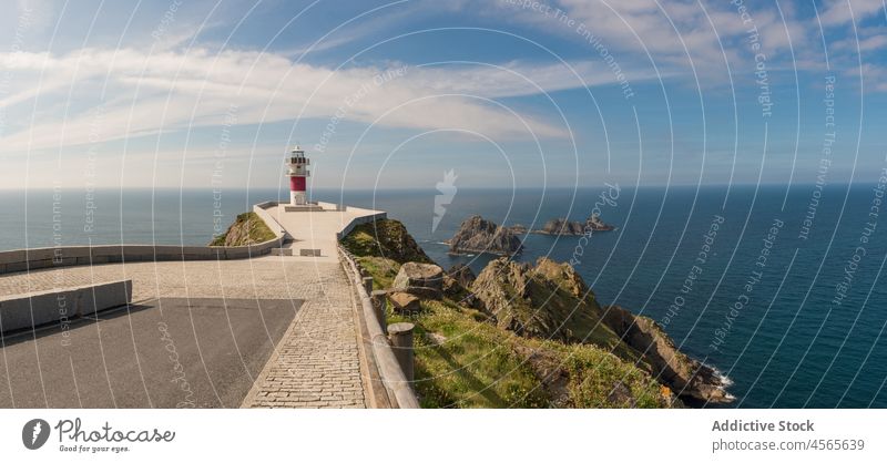 Leuchtturm auf einer felsigen Klippe bei ruhiger See an einem sonnigen Tag Meereslandschaft Meeresufer malerisch MEER spektakulär Küste Spanien Galicia Seeküste