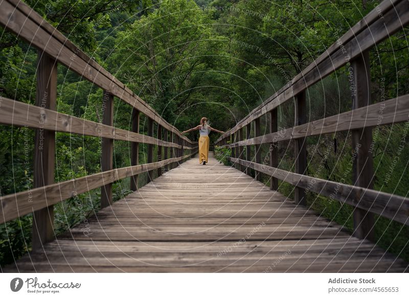 Junge Frau steht auf einem Holzsteg in einem grünen Bergtal Steg Fluss Mao Galicia Sakrament Spanien Reisender Brücke Natur Tourismus Tourist reisen erkunden