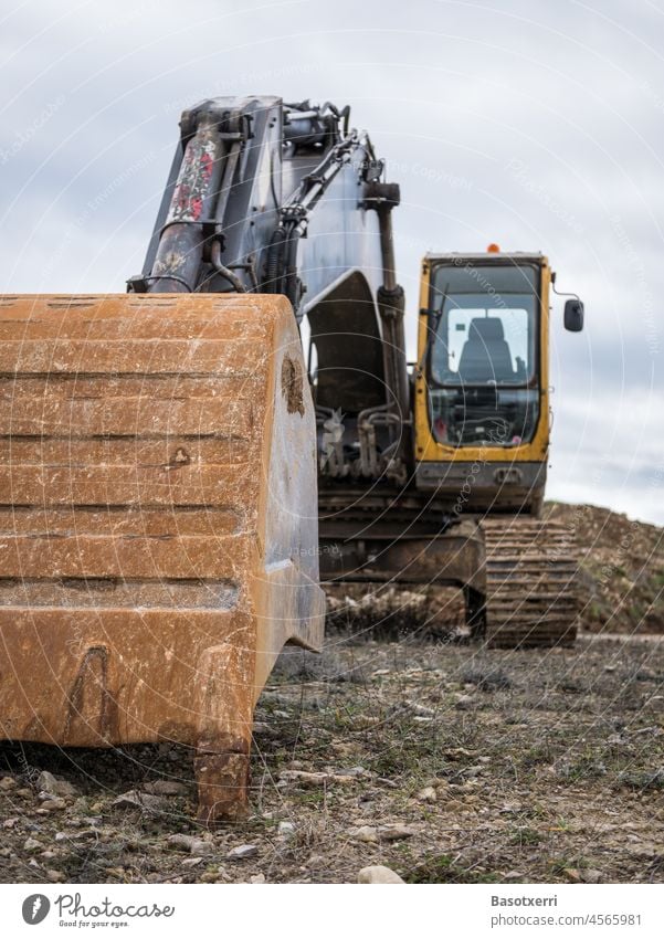 Bagger mit Schaufel im Vordergrund Löffel Baustelle Arbeit & Erwerbstätigkeit Maschine Außenaufnahme Farbfoto Baumaschine Industrie Menschenleer