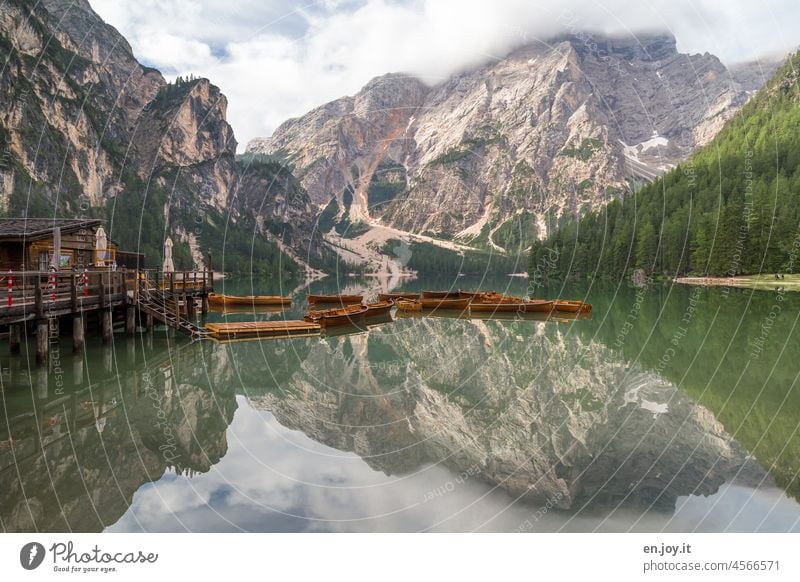 Spiegelungen von Bergen, Wälder und Bootshaus im Pragser Wildsee See Bergsee Wassertropfen Hütte Boote gebunden Ruderboot Wolken Gebirgssee Gebirge Wald Ufer