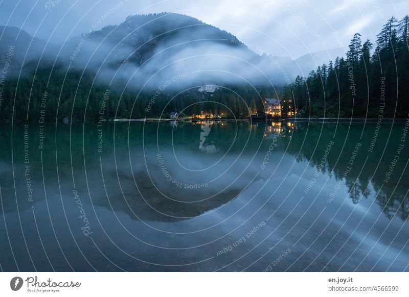 Bergsee in der blauen Stunde Pragser Wildsee blaue Stunde Berghang Hotel erleuchtete nacht lichter Nebelbank Spiegelung im Wasser Reflexion & Spiegelung