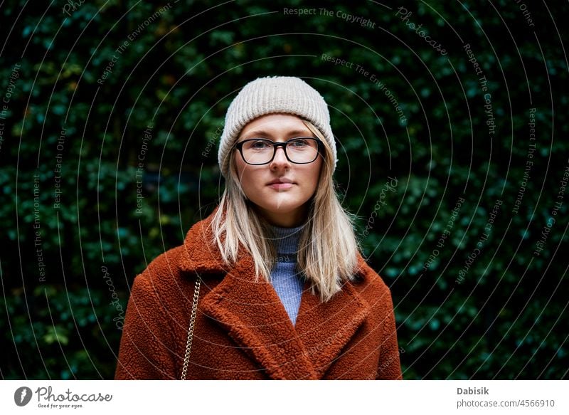 Frau im Mantel vor natürlichem Hintergrund Porträt Spaziergang grün Lifestyle Brille Natur authentisch im Freien laufen Mode Herbst gehen Sie Stil Mädchen