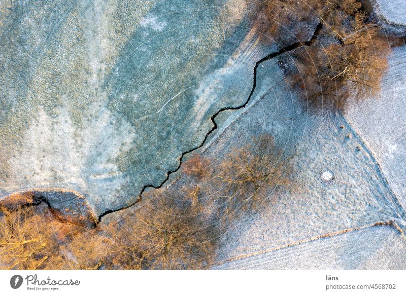 Bachlauf durch verschneite Wiesen Fluss Winter Schnee frostig Luftaufnahme Draufsicht Drohnenansicht Landschaft Natur Frost Baum von oben Umwelt Menschenleer