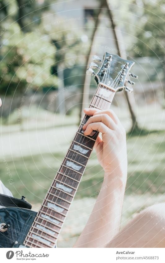 Nahaufnahme eines Paares von Händen, die im Freien eine Gitarre spielen. Sonniger Tag und üben ein Instrument Konzept. Kopieren Sie Raum Musik Leben auf Tour und Natur.