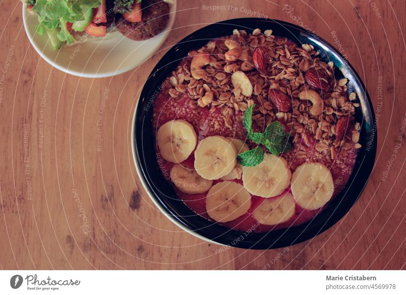 Draufsicht auf eine gesunde vegane Smoothie-Bowl aus roten Drachenfrüchten, Bananen mit Haferflocken, Cashewnüssen und Mandeln Veganismus keine Menschen