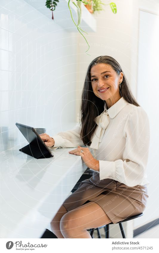 Fröhliche Geschäftsfrau beim Surfen auf dem Tablet im Büro Frau Tablette Browsen online Internet Arbeit Arbeiter Unternehmen Mitarbeiter Arbeitsplatz