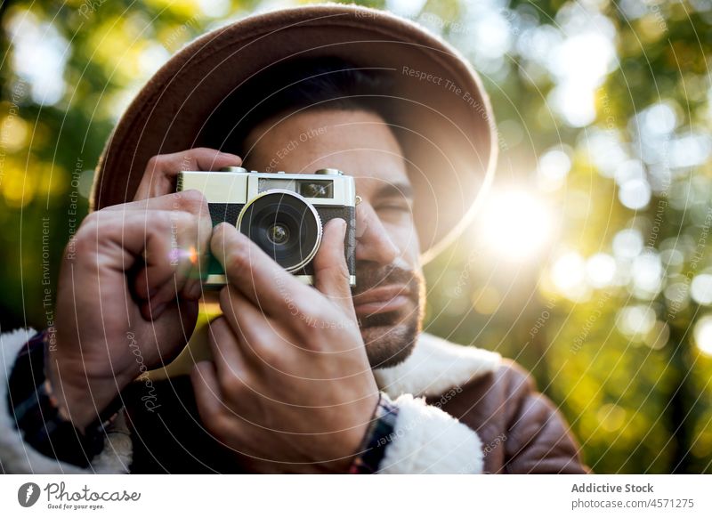 Mann fotografiert auf der Straße stehend Baum Weg Fotoapparat fotografieren Fotograf Natur Hain Erholung Stil Porträt Abenteuer Ausflug Freizeit Outfit trendy