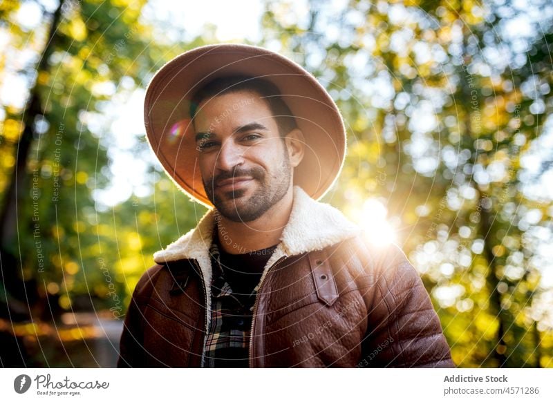 Glücklicher Hipster im Wald mit grünen Bäumen stehend Mann Baum Natur Stil Hain Abenteuer Ausflug Erholung Wälder Freizeit Outfit trendy Hut Sommer anhaben