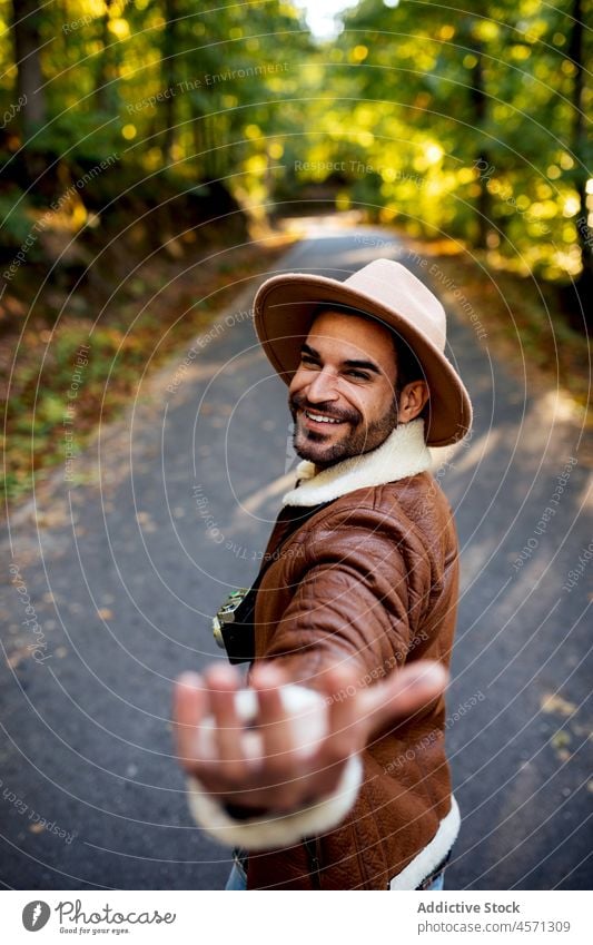 Lächelnder Mann auf der Straße in der Natur sich[Akk] melden Baum mir folgen Weg Stil Hain Abenteuer Ausflug Erholung Freizeit Outfit trendy Hut Sommer heiter