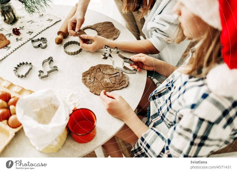 Zwei Schwestern bereiten Pfefferkuchen für Weihnachten vor. Vorbereitung auf Weihnachten und Neujahr, Weihnachtsplätzchen. Seitenansicht Koch Küche Teigwaren