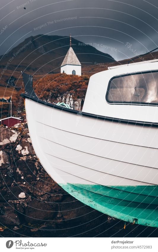 Färöer Inseln: Blick auf Boot, Kirche und Berge Gelände Berghang schroff abweisend kalte jahreszeit Dänemark Naturerlebnis Abenteuer majestätisch Neugier