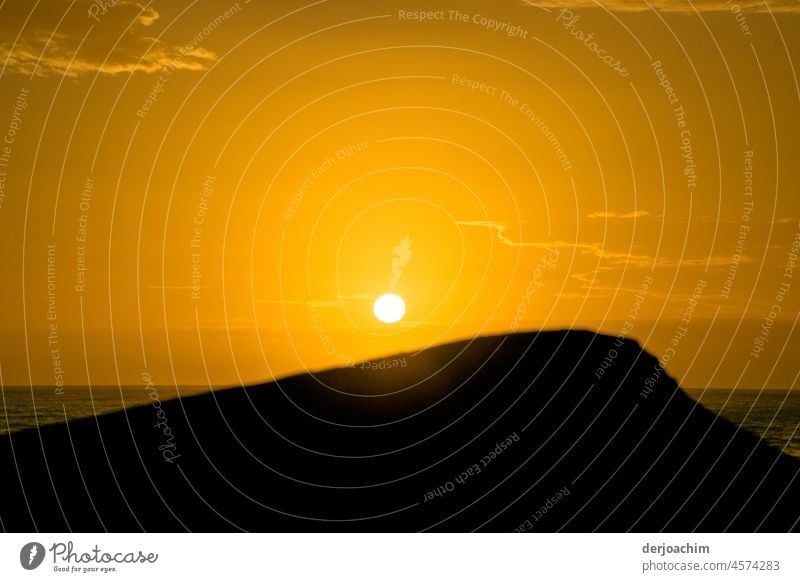 Die Sonne verschwindet gleich im Meer. Der Himmel ist in der Farbe  Orange getaucht. Sonnenuntergang Abend Abenddämmerung Stimmung Außenaufnahme Menschenleer