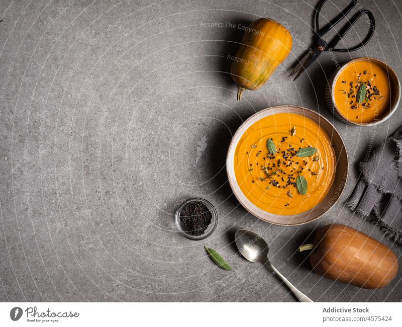 Leckere Kürbissuppe auf grauem Tisch Suppe Schalen & Schüsseln lecker Gemüse Feinschmecker geschmackvoll Küche Lebensmittel Löffel dienen gesunde Ernährung