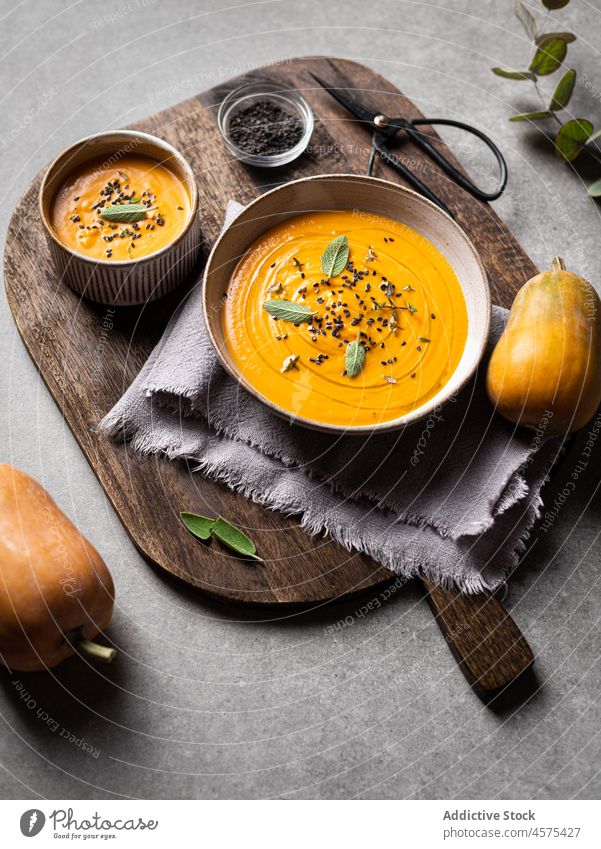 Leckere Kürbissuppe auf einem Holzbrett Suppe Schalen & Schüsseln lecker Gemüse Feinschmecker geschmackvoll Küche Lebensmittel Tisch Löffel dienen