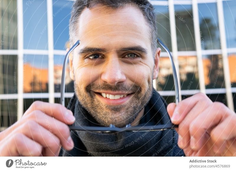 Positiver Mann mit Brille auf der Straße Lächeln heiter froh Glück positiv urban Inhalt männlich Sonnenbrille Stil Vollbart Optimist Freude Apparatur trendy