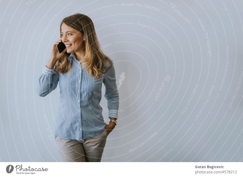 Geschäftsfrau mit Mobiltelefon an der Wand im Büro Glück Frau Person Internet Nachricht Arbeit Schönheit Apparatur freundlich Werbung trendy Mitteilung