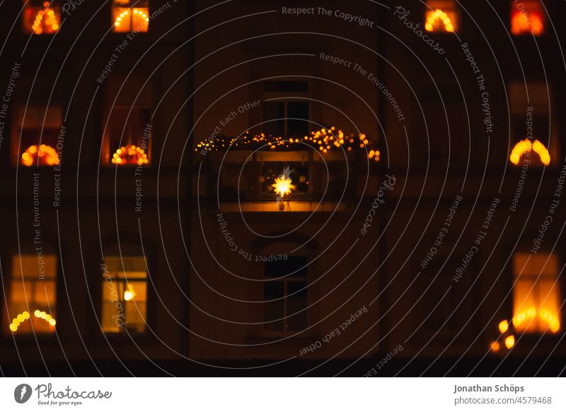 Weihnachtsbeleuchtung an einem Mehrfamilienhaus in den Fenstern Lichterkette Weihnachten & Advent draußen dunkel abend leuchten Beleuchtung Deko