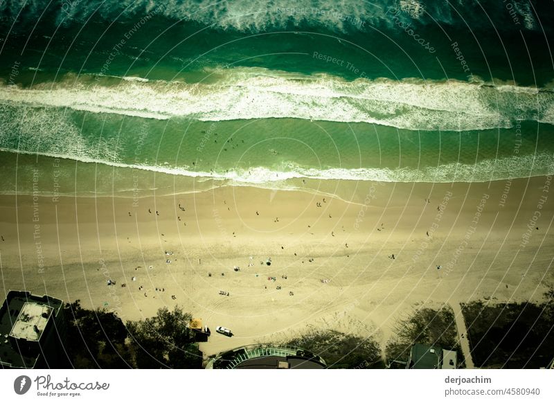 Ein aussergewöhnlicher Blick aus dem 70 Stock auf den Pacific  Strand auf ganz kleine Menschen in Surfers Paradise, Queensland. Das Meer kommt in großen Wellen an den Strand.