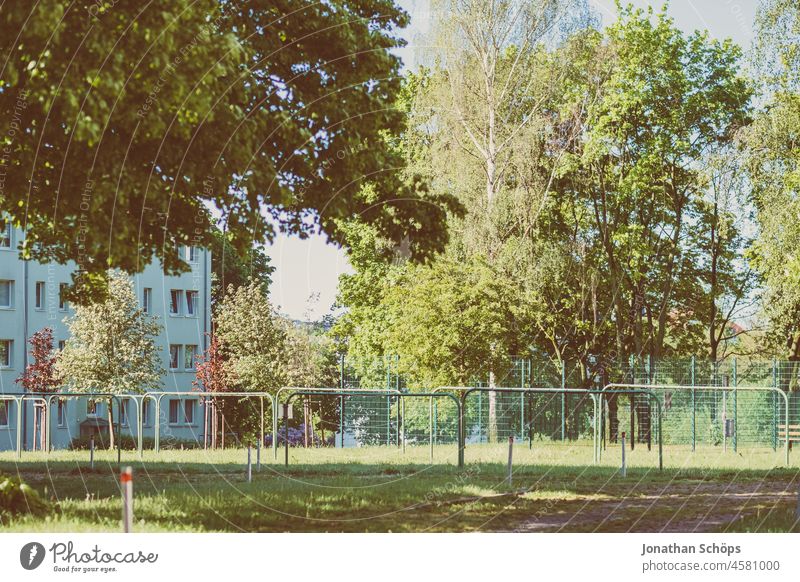 Wiese mit Wäschestangen, grünen Bäumen und Wohnblock Hof Garten Baum Sommer wohnen wohnumfeld Miete Wohnhaus Mehrfamilienhaus Idylle begrünen wohnhaus