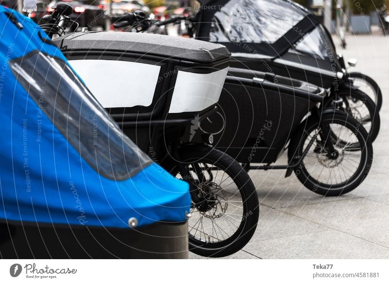 moderne Lastenfahrräder in einer Reihe in einer Stadt Lastenfahrrad Großstadt Fahrräder moderne Fahrräder grüne Ladung Stadtfracht stabile Fahrräder Fahrrad