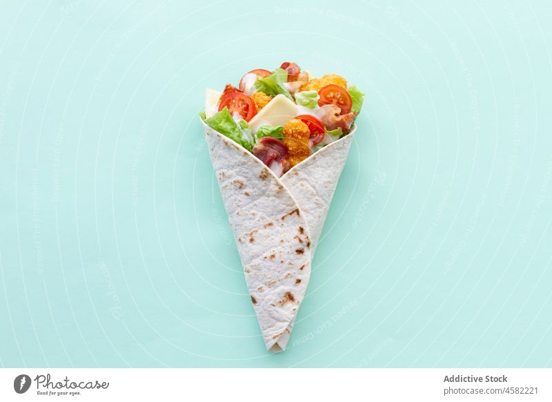 Hähnchen-Wrap mit Tomaten und Käse umhüllen Tortilla Lebensmittel Salat Snack Mahlzeit Fastfood geschmackvoll lecker frisch Gemüse Tisch Ernährung farbenfroh