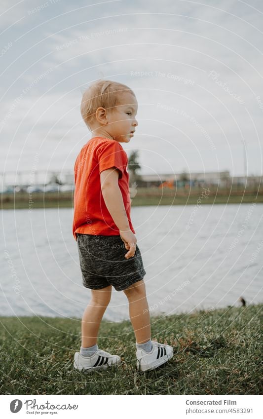 Kleiner Junge mit Stil geht neben einem Teich mit Enten Kleinkind niedlich Kindheit Frühling Spaß reisen Abenteuer Stil für kleine Kinder Kleiner Junge Stil