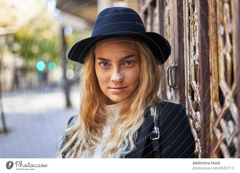 Junge Frau in Hut und Mantel lehnt an einem Ziertor Tür Gebäude Gateway Stil Ornament gealtert Architektur Mode Straße trendy Stadt Haus Outfit Großstadt