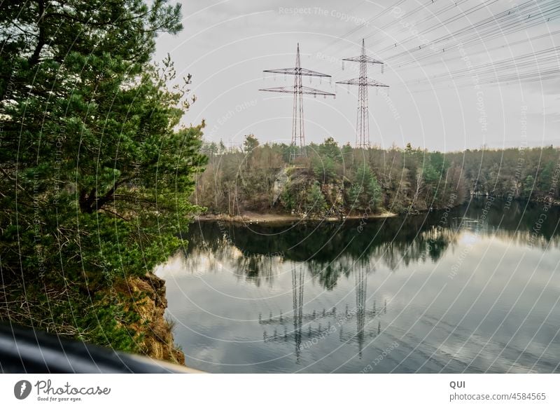 Strom im Grünen Wasser Natur Gewässer Strommast Leitungen Wald Naturschutz Baum Steinbruch Metall grün grau blau Zivilisation Erholung Ausblick Entspannung